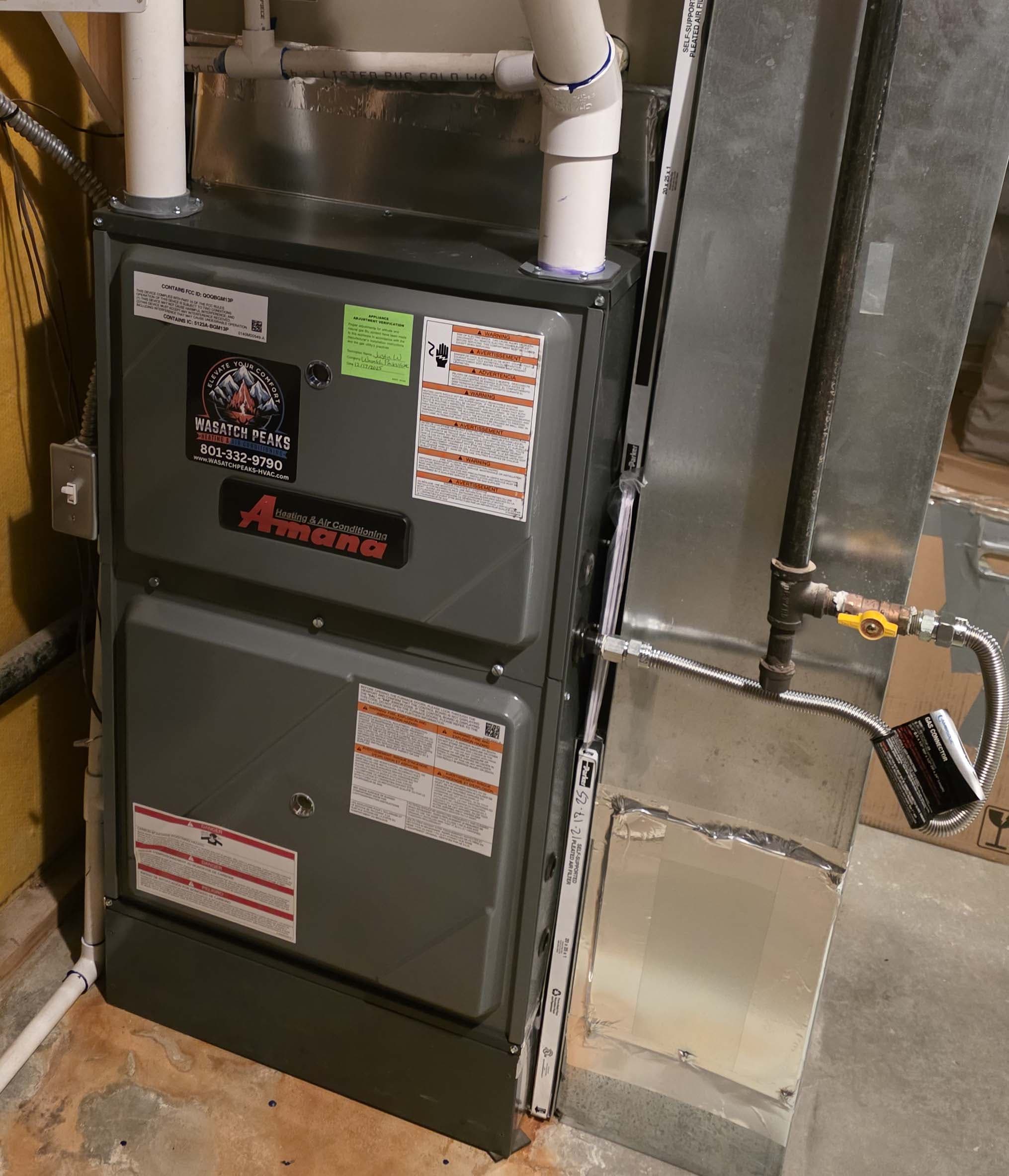 Amana high-efficiency furnace install with Wasatch Peaks branded service tag
